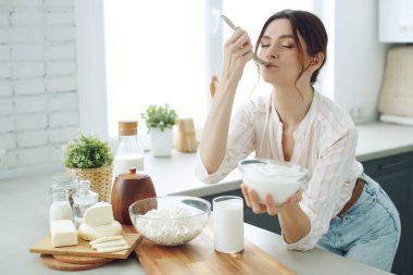 Mutfakta sütü olan genç bir kadın..