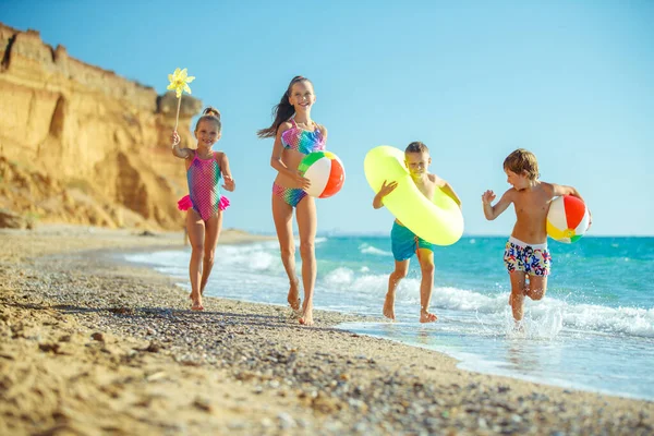 Çocuklar deniz kenarında oynar ve karpuz yerler..
