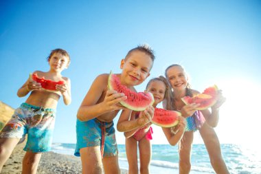 Denizdeki çocuklar. Bir grup çocuk karpuz yiyor..