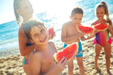 Denizdeki çocuklar. Bir grup çocuk karpuz yiyor..