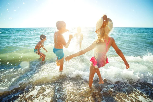 Kinder haben im Sommer Spaß am Sandstrand. — Stockfoto