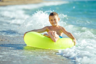 Çocuk denizde eğleniyor. Yaz, mutluluk, deniz ve çocuklu bir top.. 