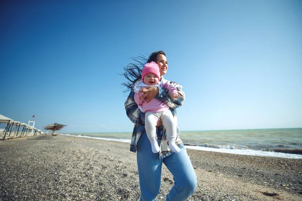一个带着孩子的女人在海边美丽的母亲和她的孩子在海边玩耍. — 图库照片