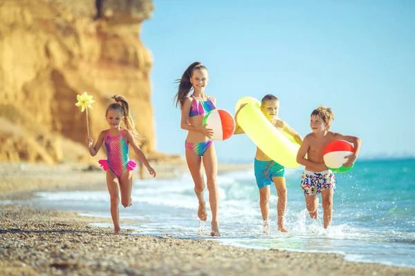 Nette Kinder genießen den sonnigen Tag am Strand. Sommerlager — Stockfoto