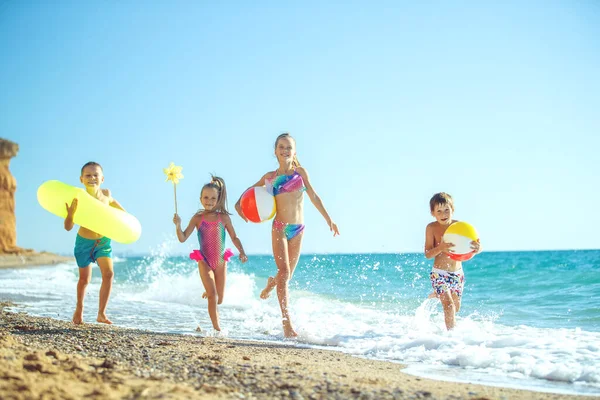 Nette Kinder genießen den sonnigen Tag am Strand. Sommerlager — Stockfoto