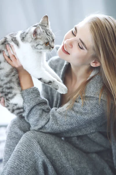 Красивая молодая женщина с милым котом отдыхает дома. — стоковое фото