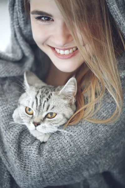 Hermosa joven con un lindo gato está descansando en casa. — Foto de Stock