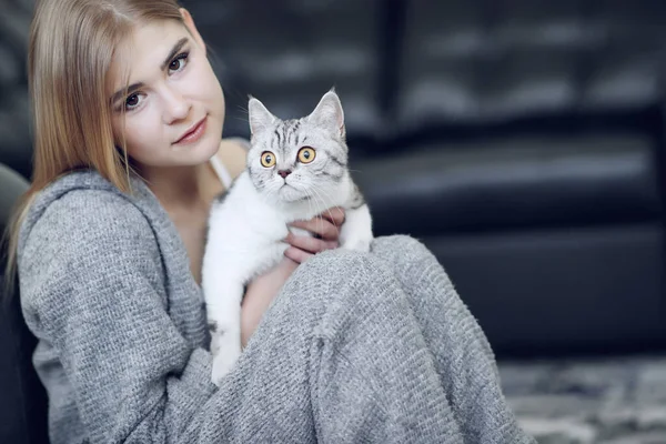Женщина дома со своей милой пушистой кошкой. Серый милый котенок с зелеными глазами. Животные и образ жизни. — стоковое фото