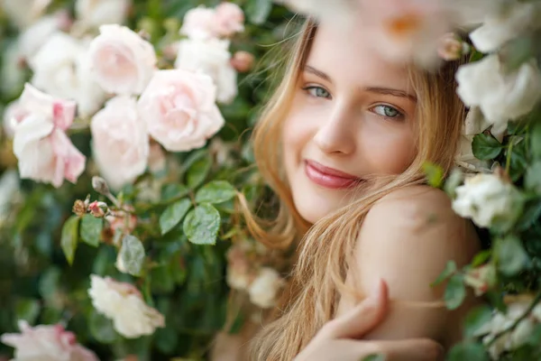Belle jeune femme sent une fleur rose — Photo