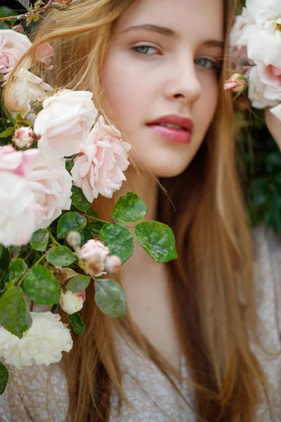 Bella giovane donna odora un fiore di rosa — Foto Stock