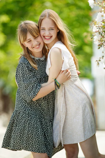 Dziewczęce siostry przytulają się w naturze. — Zdjęcie stockowe