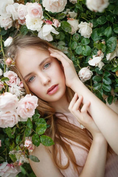 Bella giovane donna odora un fiore di rosa — Foto Stock