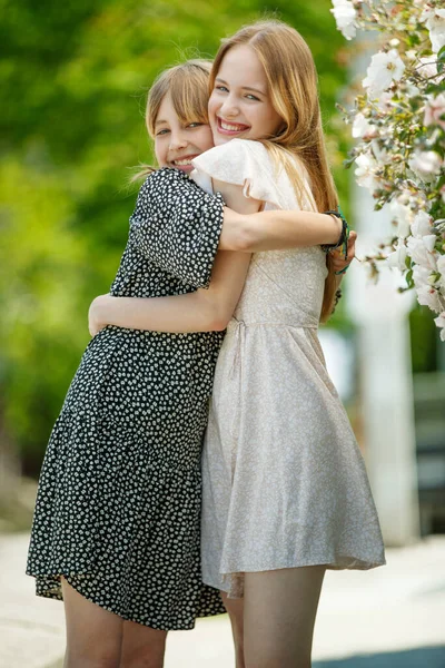 Dziewczęce siostry przytulają się w naturze. — Zdjęcie stockowe