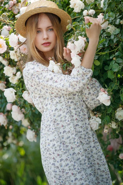 Schöne junge Frau riecht eine Rosenblume — Stockfoto