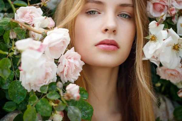 Bella giovane donna odora un fiore di rosa — Foto Stock