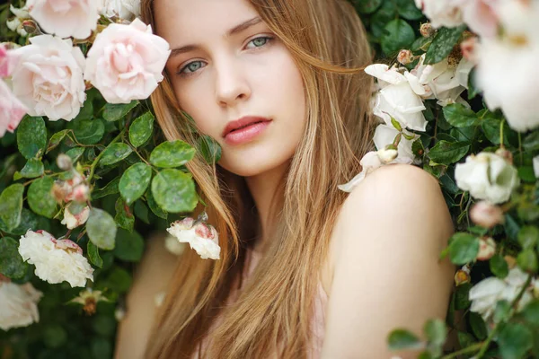 Bella giovane donna odora un fiore di rosa — Foto Stock