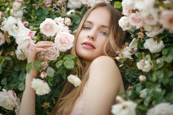 Schöne junge Frau riecht eine Rosenblume — Stockfoto