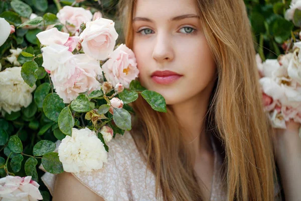 Bella giovane donna odora un fiore di rosa — Foto Stock