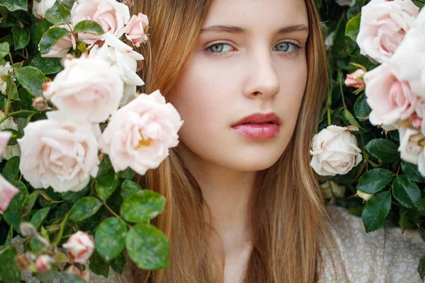 Schöne junge Frau riecht eine Rosenblume — Stockfoto