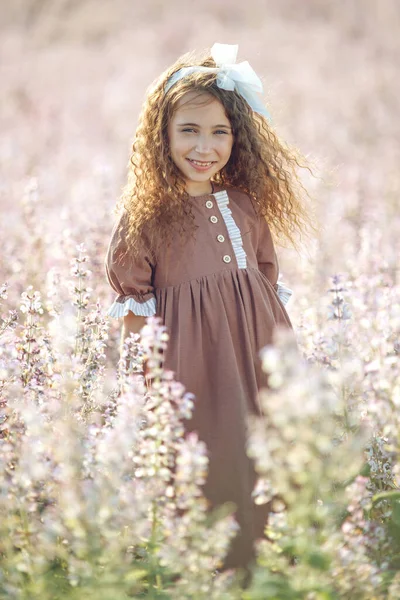 Dívka na poli s květinami. Letní večer, holčička zblízka v přírodě. — Stock fotografie