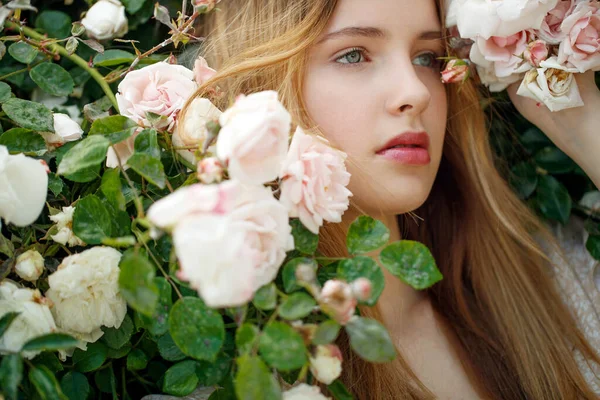 Bella giovane donna odora un fiore di rosa — Foto Stock