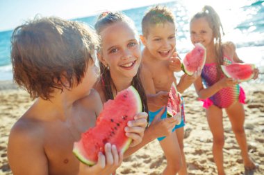 Denizde karpuzlu çocuklar. Bir grup çocuk denizde oynarken eğleniyor..