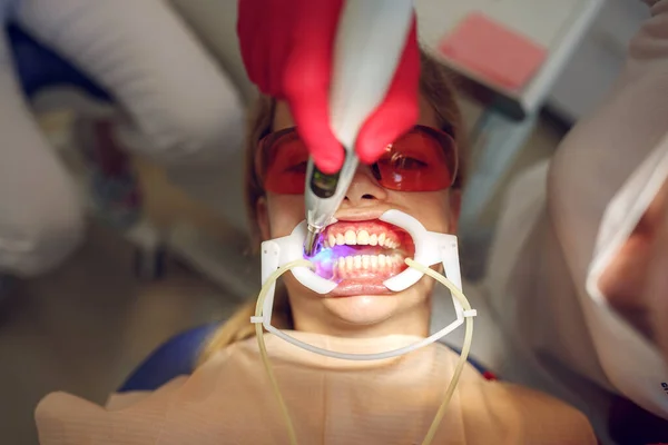 Adolescente con aparatos ortopédicos visitando al ortodoncista en la clínica. Instalación del sistema de frenado. — Foto de Stock