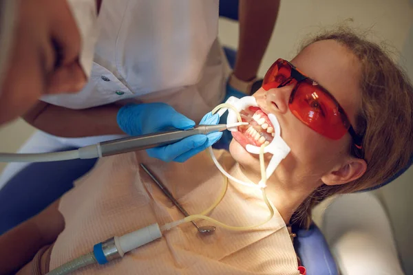Diş teli takan genç bir kız klinikteki ortodontiste gidiyor. Parantez sistemi kurulumu. — Stok fotoğraf
