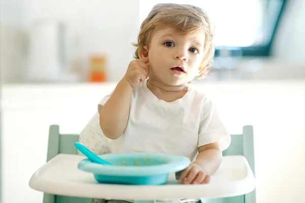 Il bambino mangia. Un bambino piccolo mangia a casa da solo. — Foto Stock