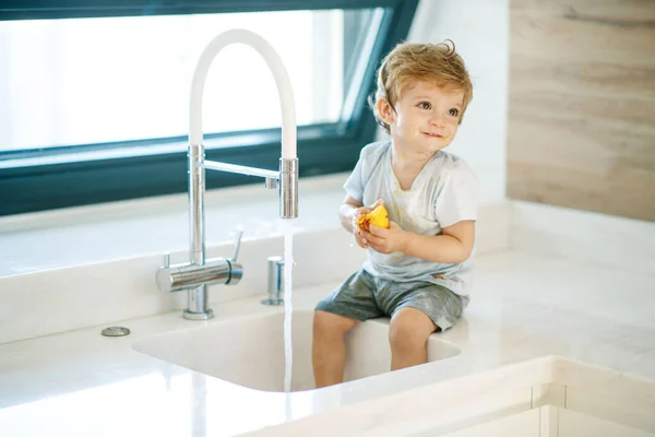 Дитина миє руки. Маленький хлопчик грає з водопровідною водою . — стокове фото