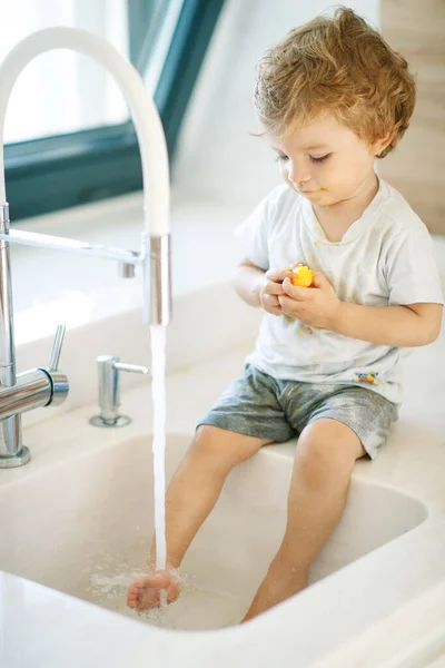Дитина миє руки. Маленький хлопчик грає з водопровідною водою . — стокове фото
