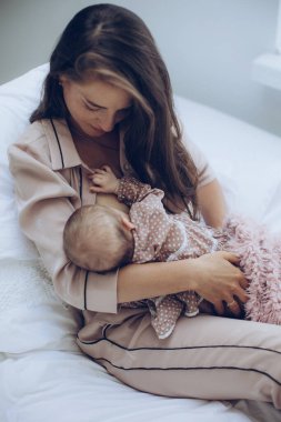 Kadın bebeği emziriyor. Genç anne bebeği besliyor..