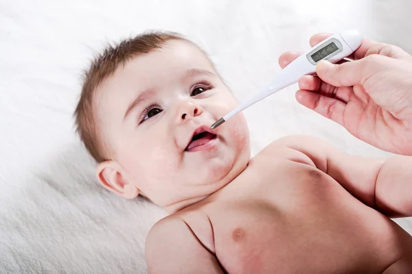 Läkare mäter temperaturen i lilla bebis. — Stockfoto