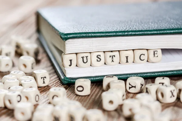 Palabra de justicia escrita en un bloque de madera . — Foto de Stock