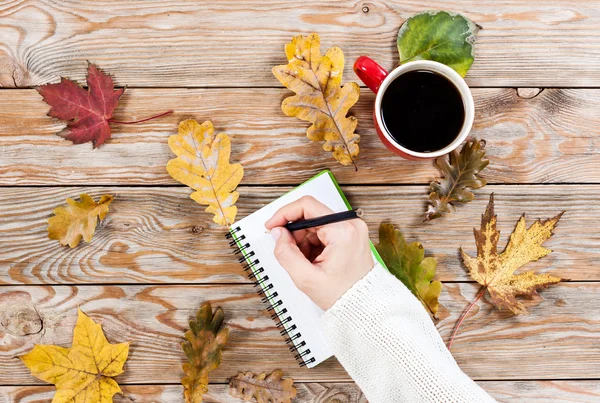 Xícara de café, caderno e folhas de outono — Fotografia de Stock
