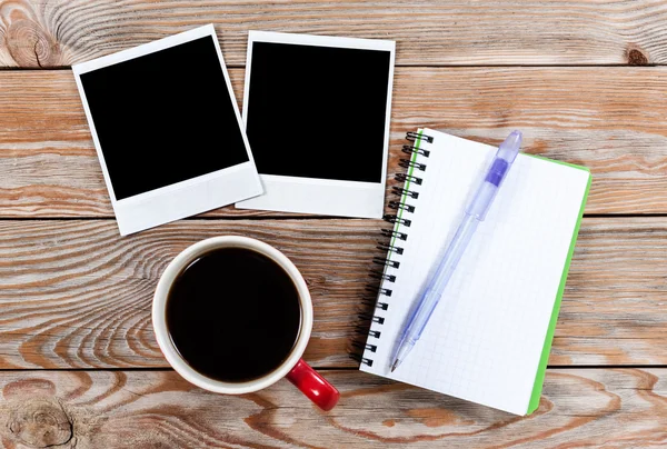 Workspace with coffee cup, instant photos, note paper and notebo