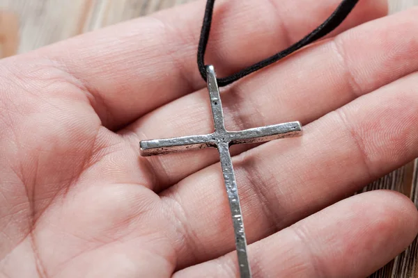 Silver christian cross in hand — Stock Photo, Image