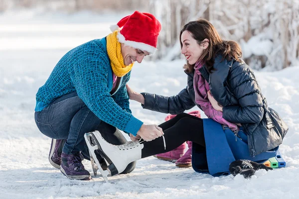 Gelukkige paar plezier schaatsen op de ijsbaan buitenshuis. — Stockfoto