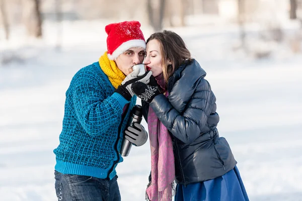 Pareja feliz divirtiéndose y bebiendo té caliente en la pista al aire libre . — Foto de Stock