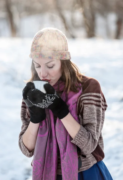 Fröhliches Mädchen trinkt heißen Tee mit Dampf im Freien. — Stockfoto