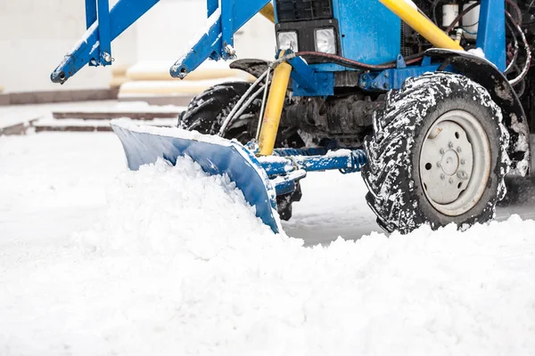 Trekker schoonmaak sneeuw in stad — Stockfoto