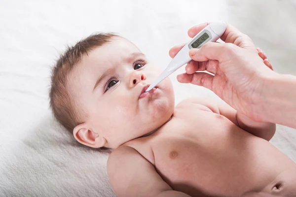 Il medico misura la temperatura del bambino . — Foto Stock