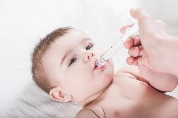 Arzt gibt einem kleinen Baby ein paar Medikamente. — Stockfoto