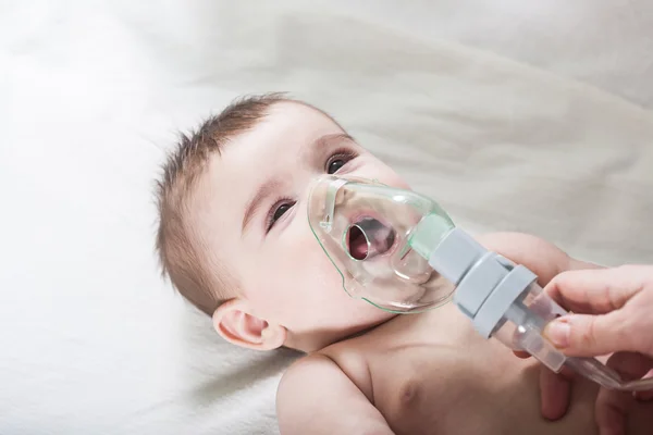 Le médecin fait l'inhalation à un petit bébé malade . — Photo