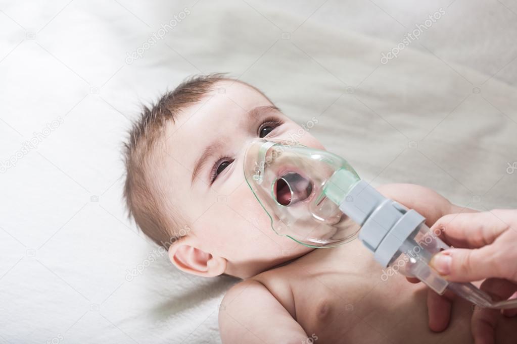 Doctor makes inhalation to a sick little baby.