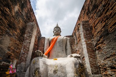 old buddha in old abandoned temple building at archaeological site somewhere in Thailand