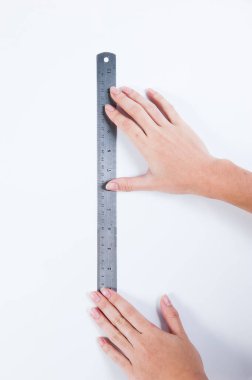 a man's hands holding stainless steel ruler to measure something