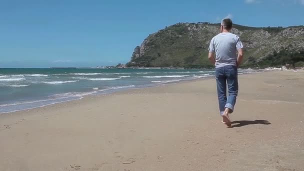 Man die over het strand loopt — Stockvideo