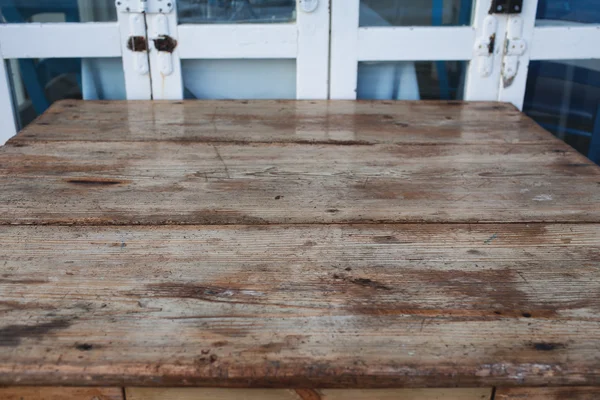 Houten tafel tegen oude deur — Stockfoto