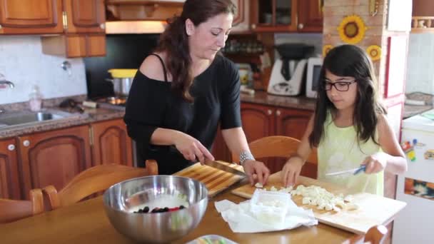 Женщина готовит еду со своей дочерью — стоковое видео